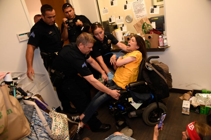 Denver police arrest Dawn Russell for refusing to leave the offices of Sen. Cory Gardner (R-Colo.) on June 29.