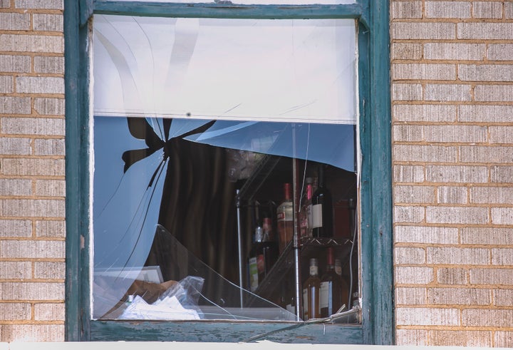 A broken window at the Ultra Power Lounge as law enforcement collects evidence on a shooting that authorities believe stemmed from a dispute during a concert. 