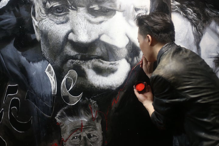 <p>Michael Andrew Law at work in his studio</p>