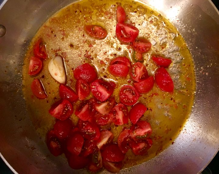 The olive oil has been infused with Aleppo pepper and garlic. Skinned cherry tomatoes added
