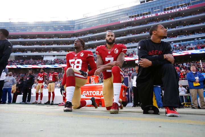 Kaepernick, center, kneels during the national anthem on Jan. 1, 2017. His teammates Eli Harold, left, and Eric Reid, right,