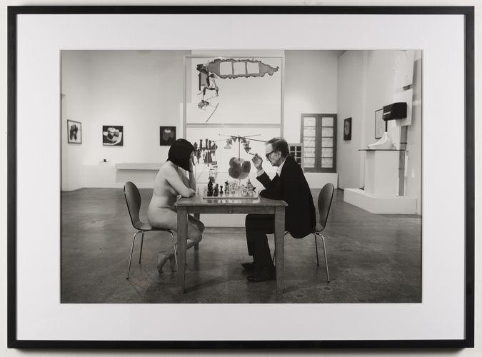 John Colao: After Julian Wasser: Julian Wasser Playing Chess with a Nude at Robert Berman Gallery, 2016. Archival pigment print, mounted to dibond. Signed by both John Colao and Julian Wasser 