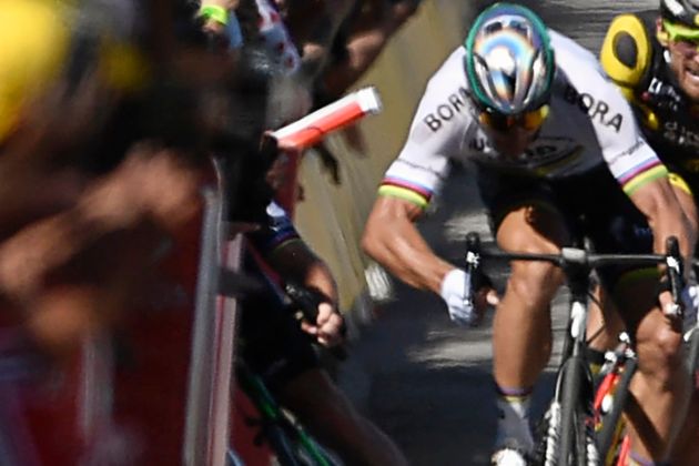 Slovakia's Peter Sagan is seen with his elbow out after hitting Great Britain's Mark Cavendish, causing him to fall into a barricade, seen left.