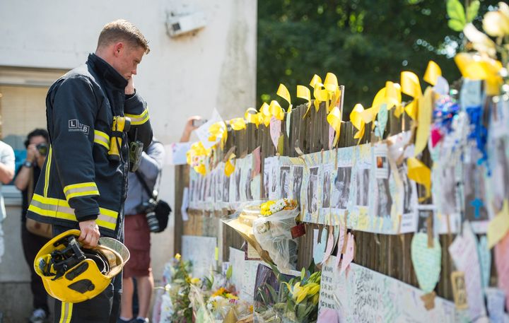A firefighter views tributes at Latymer Community Centre.