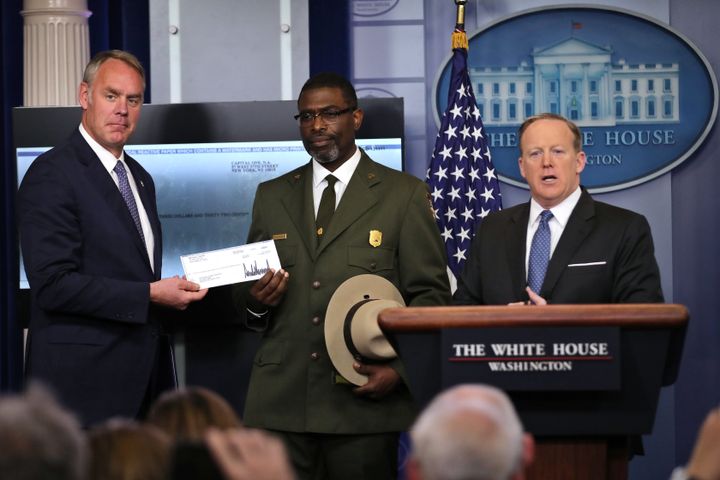 Secretary of the Interior Ryan Zinke seen holding a check announcing President Donald Trump's intended donation to the National Park Service in April.