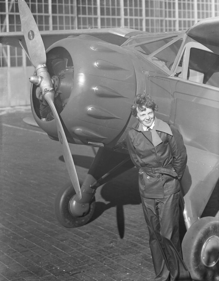 Earhart, the first woman to fly solo across the Atlantic in 1932, stands next to the propellor of her plane 