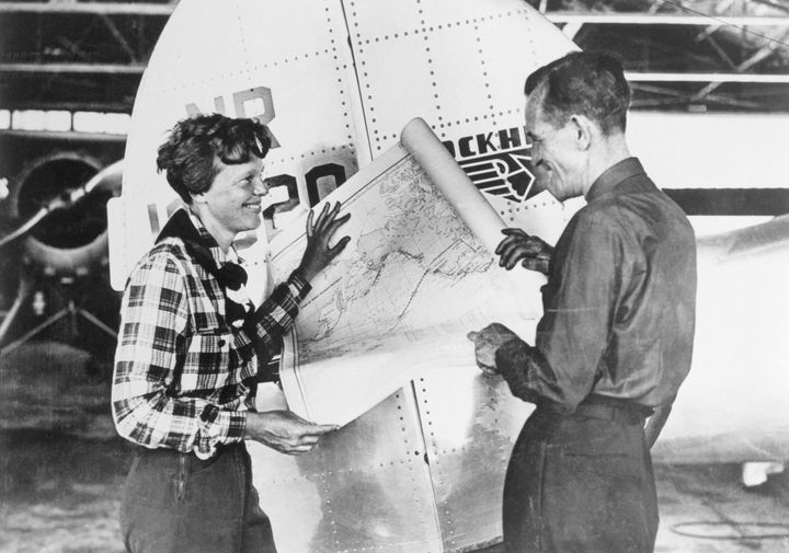Earhart and Noonan with a map of the Pacific that shows the planned route of their last flight 
