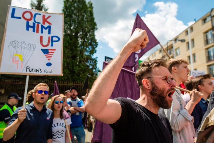 Demonstrator holds up a sign that reads: "Lock him up!"