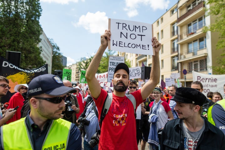 A demonstrator holds up a sign that reads: "Trump not welcome!"