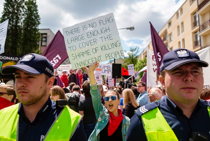 A demonstrator holds up a sign that reads: "There is no flag large enough to cover the shame of killing innocent people."