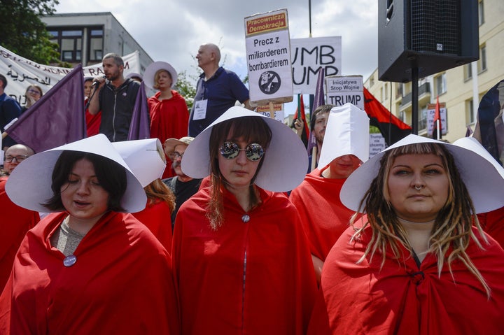 Four handmaids protest Trump's visit to Poland. 