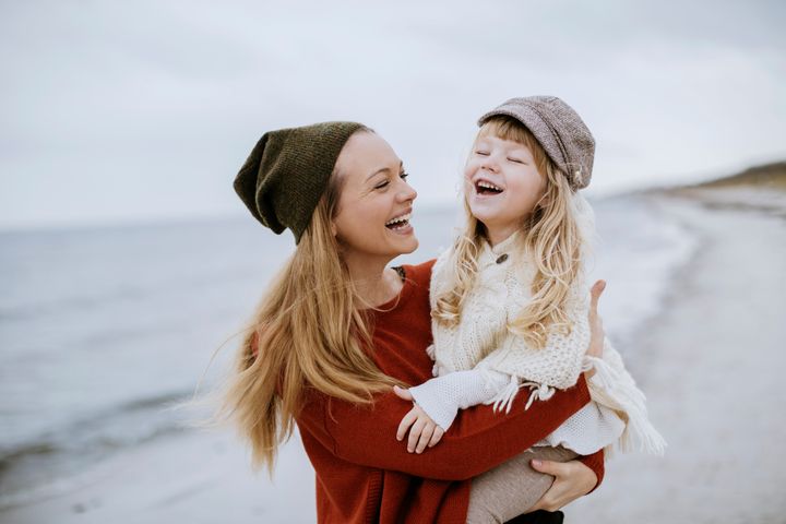 Photo of a mother and daughter playing on the beach Geber86 via Getty Images