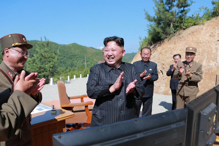 North Korean leader Kim Jong Un reacts with scientists and technicians after the test-launch of an intercontinental ballistic