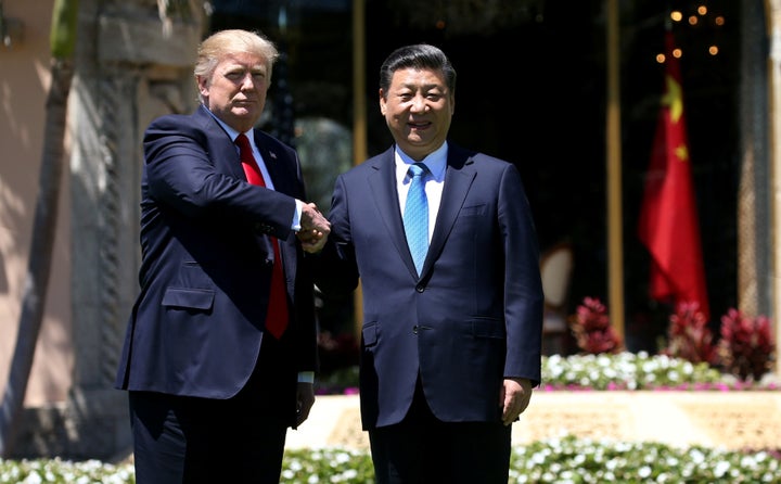 U.S. President Donald Trump and Chinese President Xi Jinping shake hands while walking at Mar-a-Lago estate after a bilateral