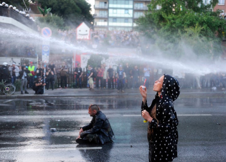 A protester blows bubbles as riot police use water cannons during the "Welcome to Hell" rally on Thursday. 