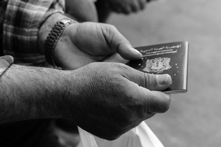 A Syrian man holds his passport outside the Syrian consulate in Istanbul on May 4, 2017.