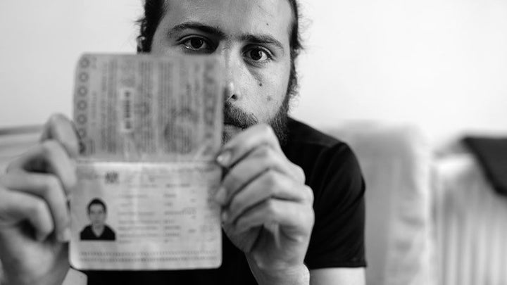 Zaher Said holds up his Syrian passport, which is about to expire, in his home in Gaziantep, Turkey on May 20, 2017.