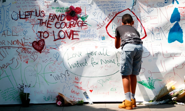 A boy writes a tributes near the scene of the 19 June van attack on pedestrians, in the Finsbury Park area of north London.