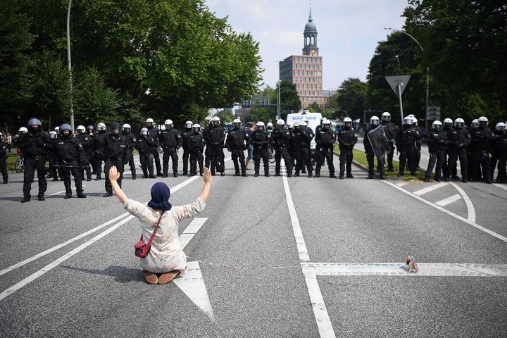 A demonstrator sits on the road in front of police 