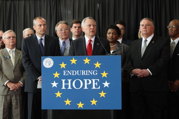 Gov. Nathan Deal (R) introduces HOPE legislation in Feb. 2011, as Rep. Stacey Abrams (D), immediately to Deal's left, looks on. Abrams was also present at the bill's signing that March.