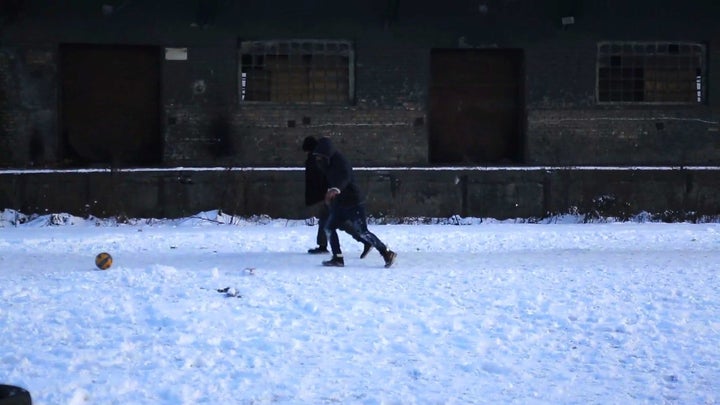 Young Afghan men play football in the snow outside the warehouses. Temperatures in Belgrade dipped to 1.5F (-17C) at night ov