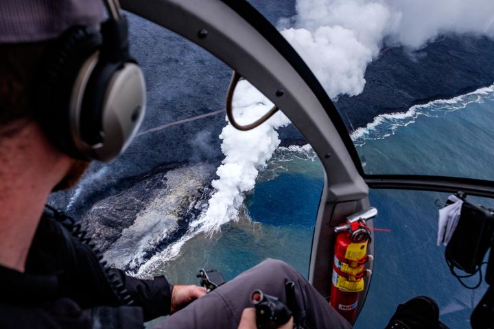 An amazing scene captured from an open-door helicopter while flying above where the Kīlauea volcano meets the largest ocean on Earth—the Pacific! 