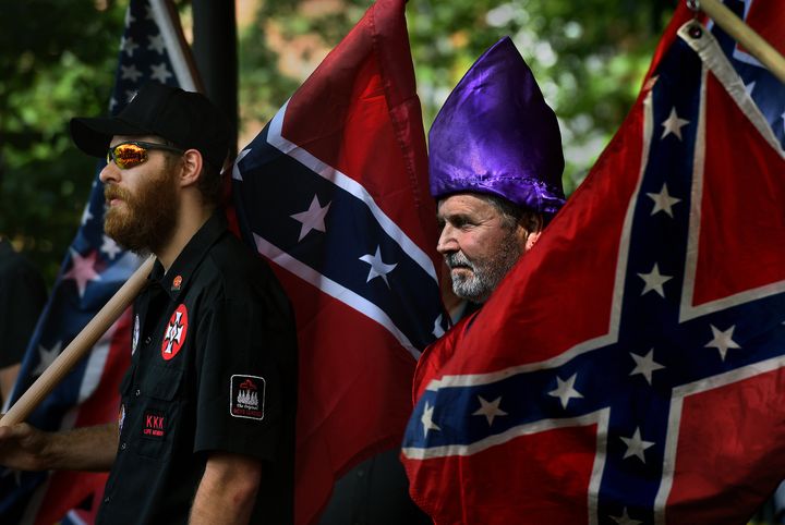 KKK members watch as anti-KKK groups chanted against them.