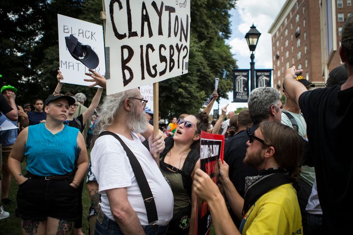 A protester throws the hat off a counter protester before a planned Ku Klux Klan protest.