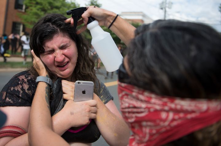 A protester has her eyes washed after being tear gassed by police following a Ku Klux Klan rally.