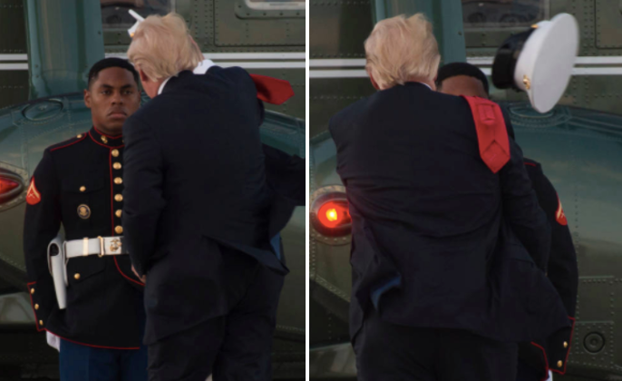 President Trump is seen attempting to return a hat to a Marine after it was blown off at Andrews Air Force Base in Maryland o