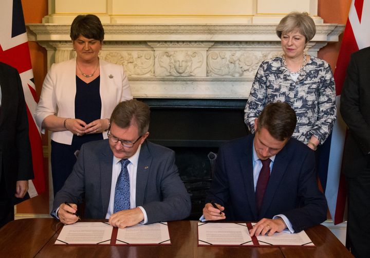 Prime Minister Theresa May stands with DUP leader Arlene Foster (left), as DUP MP Sir Jeffrey Donaldson (second right) and Parliamentary Secretary to the Treasury, and Chief Whip, Gavin Williamson, sign paperwork inside 10 Downing Street, London, after the DUP agreed a deal to support the minority Conservative government.
