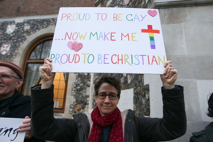 Demonstrators hold placards as they protest outside Church House, the venue of the Church of England's General Synod, in London on February 15, 2017. 