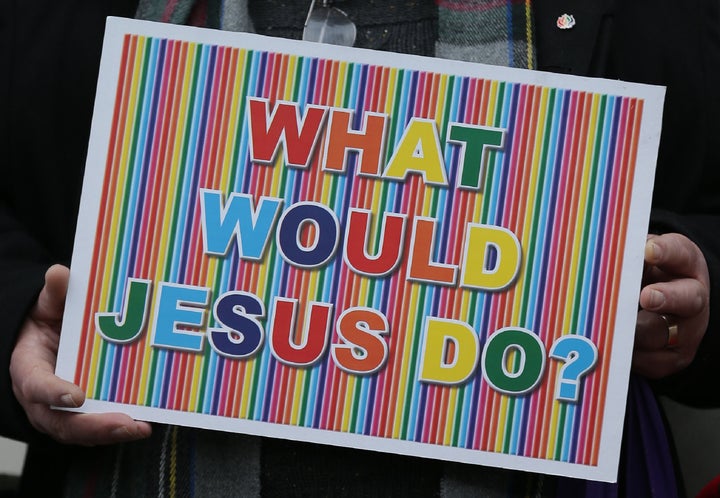 A demonstrator holds a placard as they protest outside Church House, the venue of the Church of England's General Synod, in London on February 15, 2017.