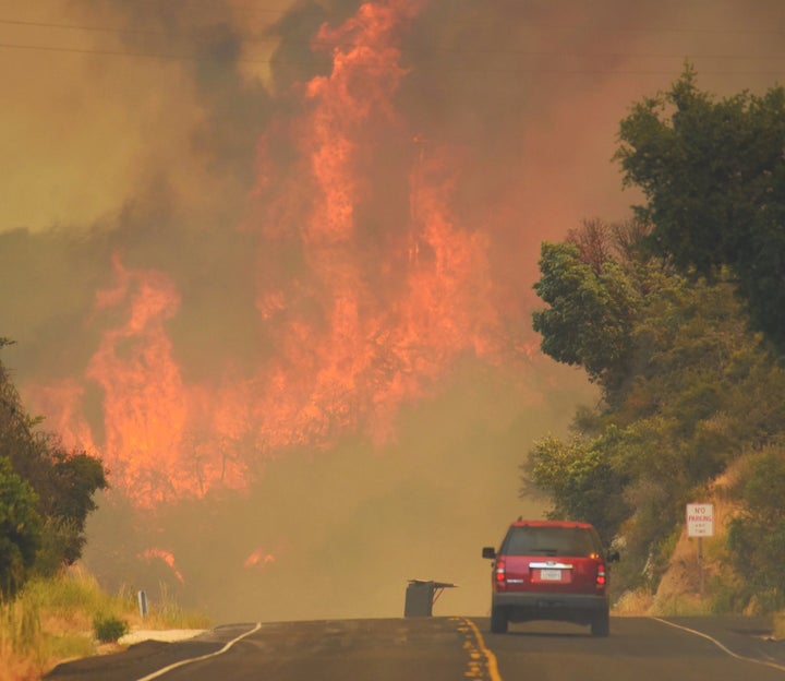 A Santa Barbara city fire vehicle drives towards flames from the Whittier Fire on July 8.