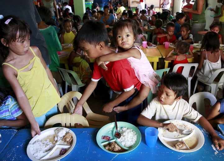 <p> Children eat free meals distributed by group World Mission Community Care in a slum in Manila. </p>