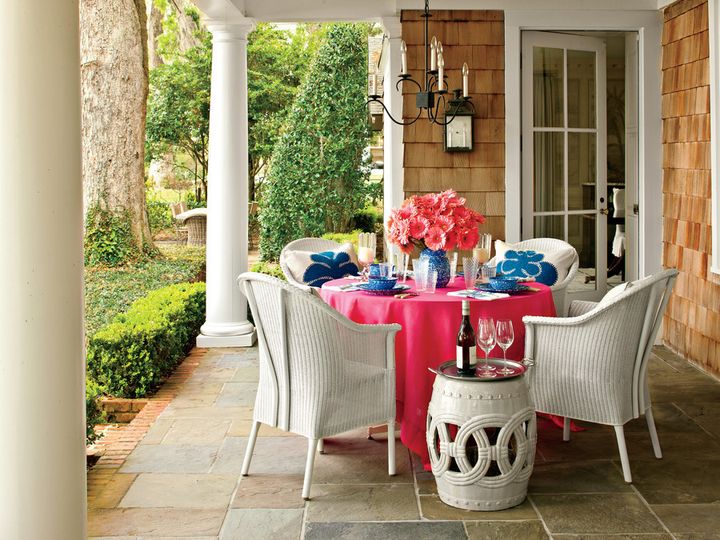 Above, a graceful chandelier adds a touch of refined style to an outdoor dining room designed by Phoebe Howard, as seen in Southern Living.