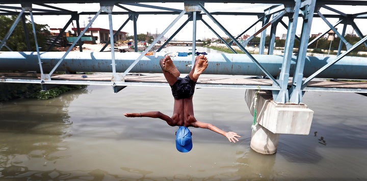  A boy jumps from a water pipe into a canal as temperatures soar in New Delhi. Access to clean and regular water remains a challenge for India’s capital. 