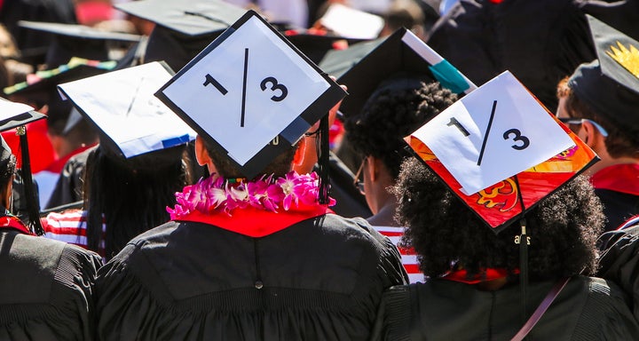 Stanford students wear a 1/3 sign on their caps to show solidarity for a Stanford rape victim during graduation ceremonies at