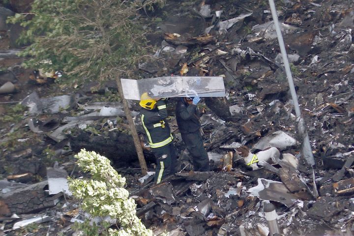Firefighters protect themselves with debris while they walk into the tower with a search dog 