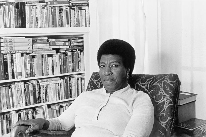 Octavia E Butler seated by her bookcase, 1986.