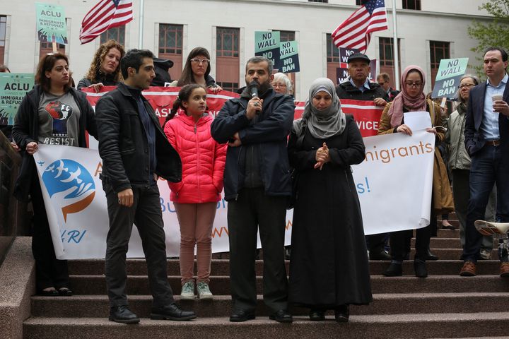 Mustafa Al-Mustafa, center right, a refugee from Syria, speaks with the help of a translator, Moh Kilani, left, while joined by his wife, Jamila Al-Mustafa, right, and daughter, Yamama, 11, center left, during a protest of U.S. President Donald Trump's travel ban outside of the U.S. Court of Appeals in Seattle, Washington, U.S. May 15, 2017. 