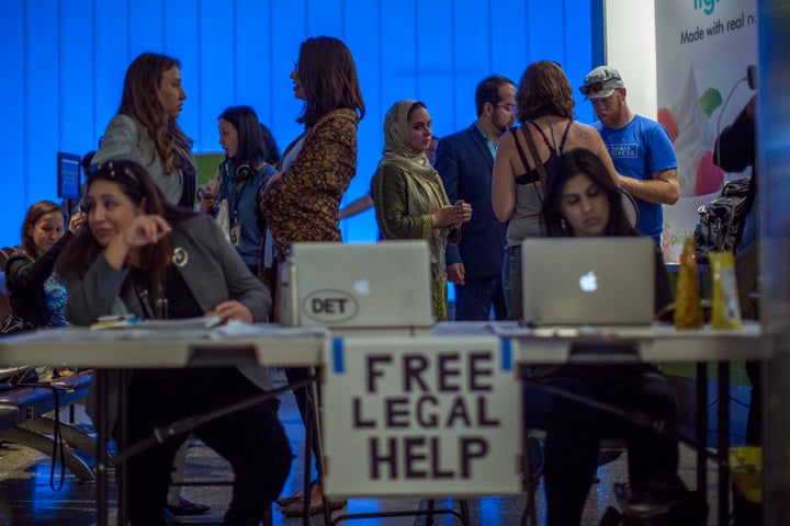 Attorneys offer free legal help to arriving international travelers on the first day of the the partial reinstatement of the