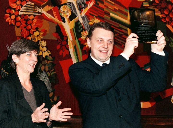 Pavel Sheremet, pictured with CPJ’s then-executive director Ann Cooper, lifts his International Press Freedom Award during a ceremony in 1998. 