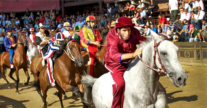 Jockeys race their horses around the difficult to maneuver shell-shaped Piazza del Campo