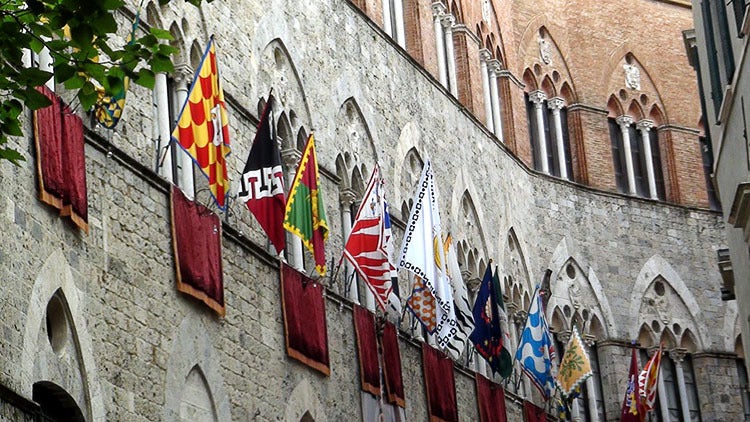Flags representing the 17 Contrade, or distrcits, of Siena line the streets