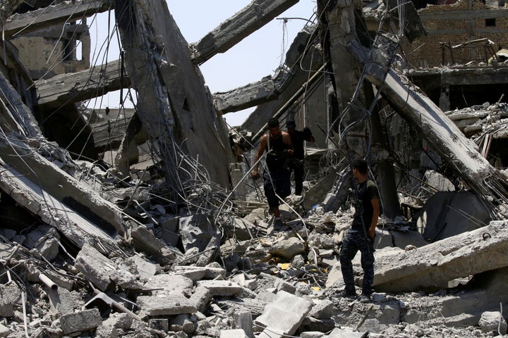 Iraqi security forces walk along destroyed buildings from clashes in the Old City of Mosul on July 10.