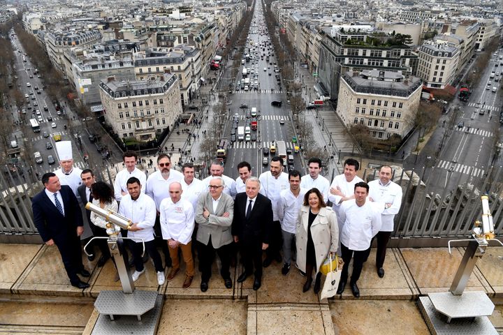 French chef Alain Ducasse (front row, 4L) and French Foreign Affairs minister Jean-Marc Ayrault (front row-5L) pose for a picture with French chefs on top of the the Arc de Triomphe (Arch of Triumph) on March 21, 2017 in Paris