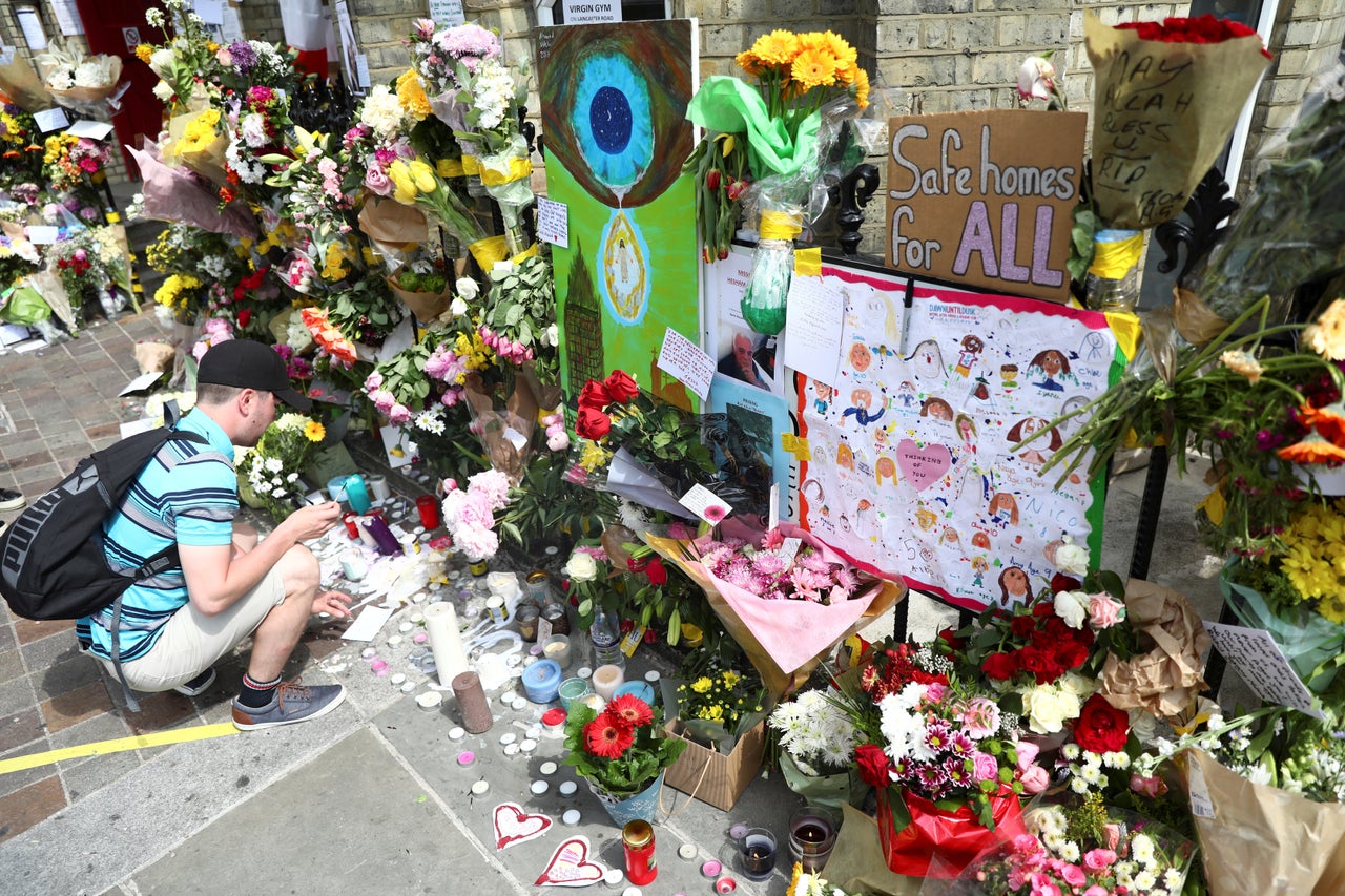 <strong>A man leaves a tribute for the victims of the Grenfell Tower fire.</strong>