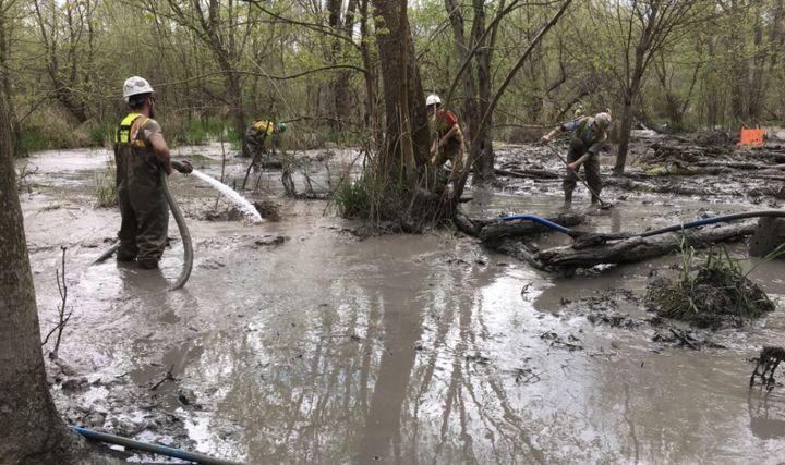 Workers vacuum, hose down and brush more than a foot of slurry spilled from a construction site along the Rover pipeline in Ohio. 