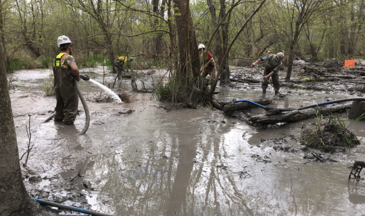 Workers vacuum, hose down and brush more than a foot of slurry spilled from a construction site along the Rover pipeline in Ohio.